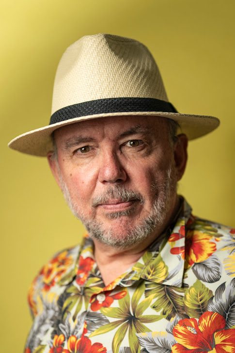 Charlie Lark in a straw hat and floral shirt